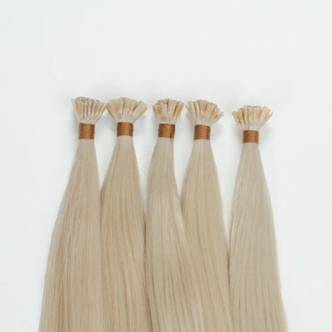 Blonde raw hair extension bundles with keratin tips from Prolonged Hair on white background